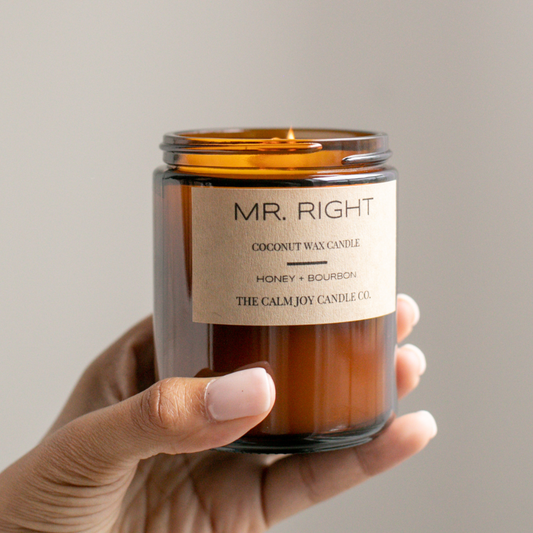Hand holding a candle labeled 'Mr. Right' with a beige background