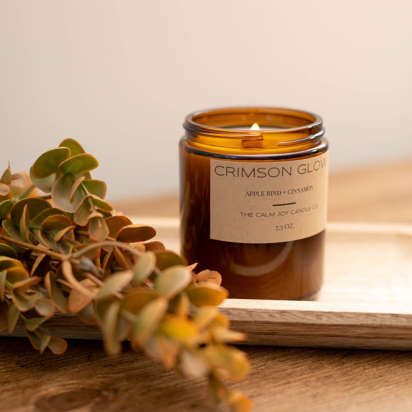 amber glass jar candle with lit wooden wick