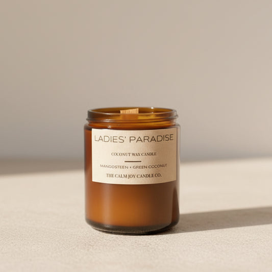 Candle labeled 'Ladies' Paradise' with plants in the background
